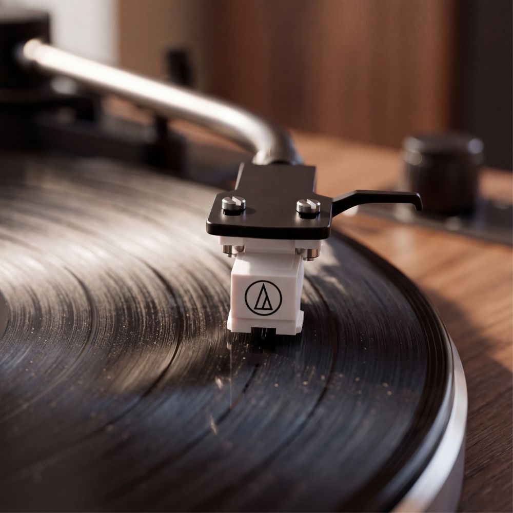 Gros plan sur la cellule Audio-Technica de la platine Volute Noyer lisant le sillon d'un disque